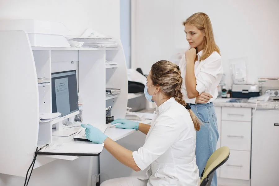 Clinic staff reviewing patient data together on a computer screen