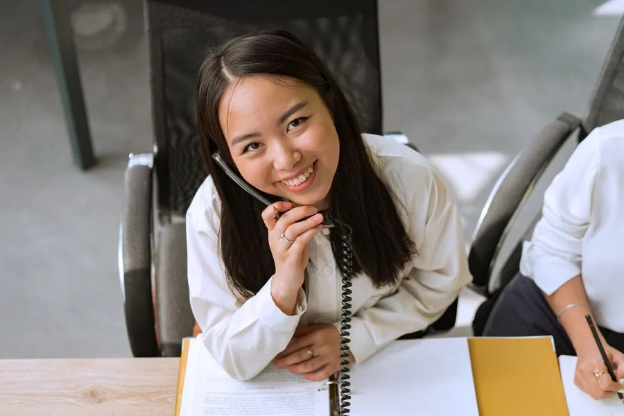 A dental practice team member on a call with a patient at the front desk