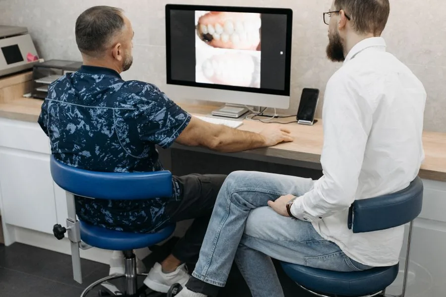 A dentist and patient reviewing orthodontic scans on screen together
