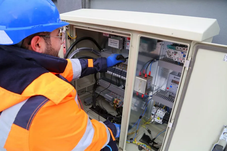 An electrician working on a control panel