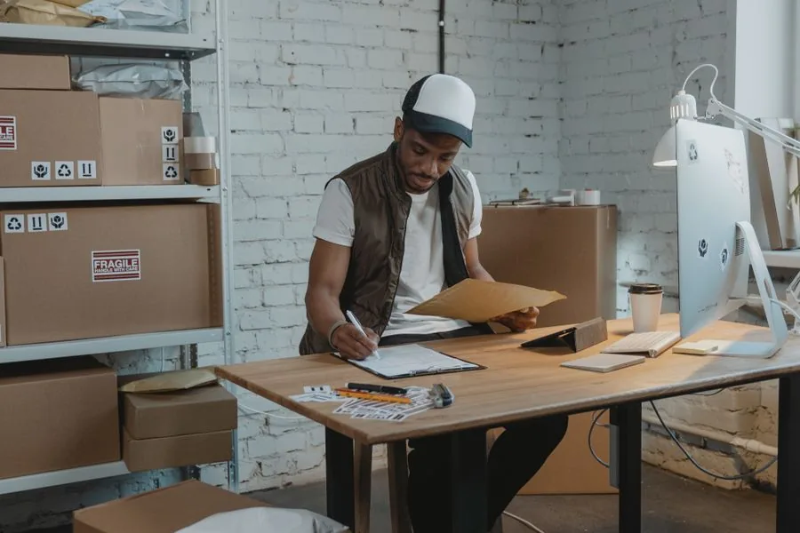A DTC brand owner preparing product packaging at a fulfillment desk