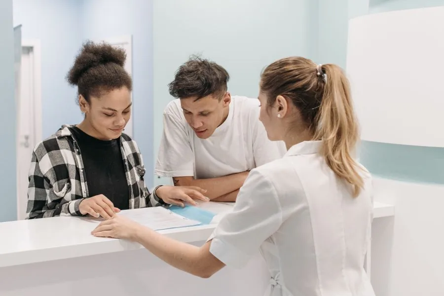 Clinic reception staff assisting patients at the front desk