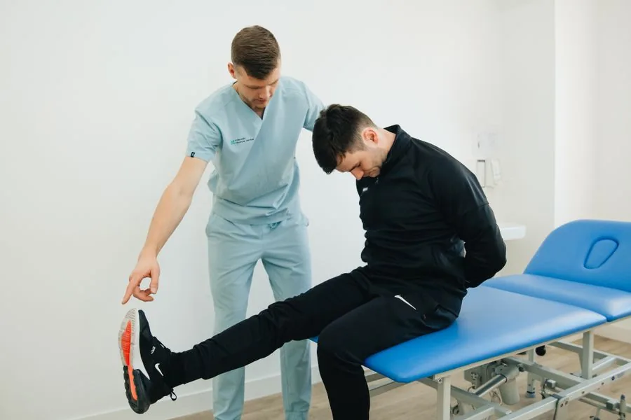 A physiotherapist guiding a patient through a stretching assessment