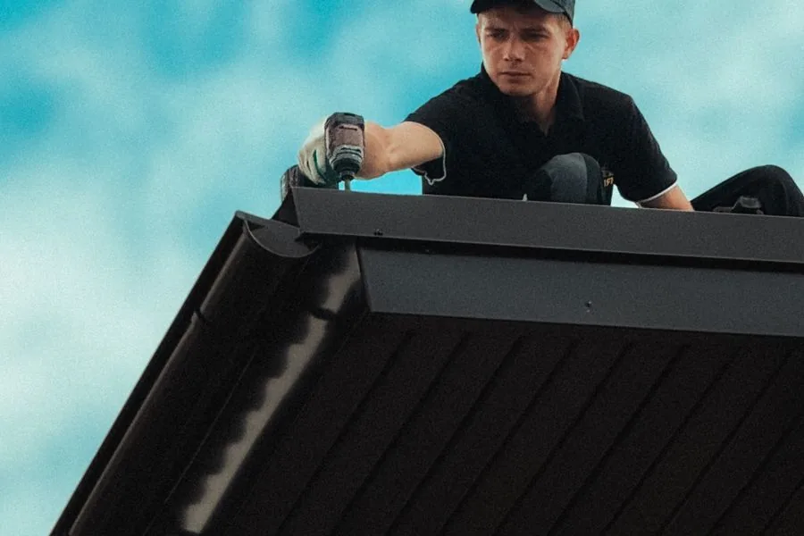 A roofer working on an emergency repair against a dramatic sky