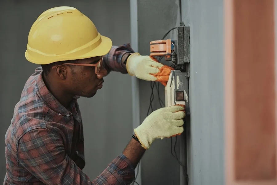 Electrician in a hard hat wiring an electrical panel on a job site